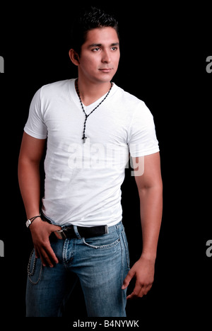 Studio shot of a toned young man wearing a white t-shirt and blue jeans, over a black background Stock Photo