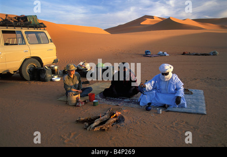 Algeria near Djanet Sanddunes Tourists camping with people of Tuareg tribe 4x4 car Sahara Desert Stock Photo