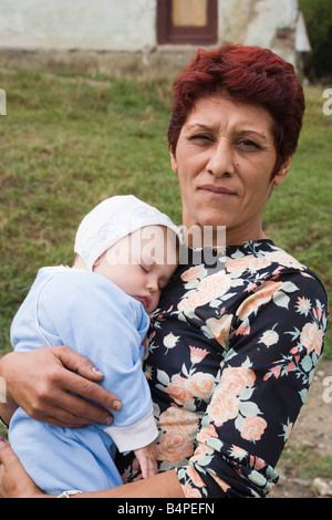 Romania Proud grandmother holding sleeping baby boy Stock Photo