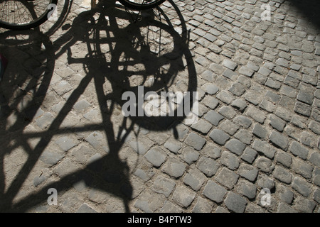 bikes shadow on sidewalk road in sun Stock Photo