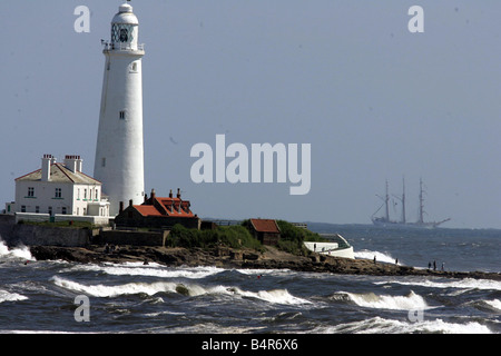 Tall ships Race July 2005 One of the Tall Ships off the North East coast passes St Mary s Lighthouse as it prepares to enter the River Tyne Stock Photo