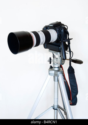 Canon digital SLR camera mounted on tripod with telephoto zoom lens and electronic cable release fitted Stock Photo