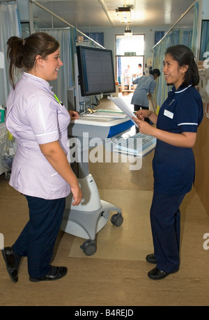 A ward sister smiles as she uses 'COWS', computers on wheels, in an acute care unit. Stock Photo