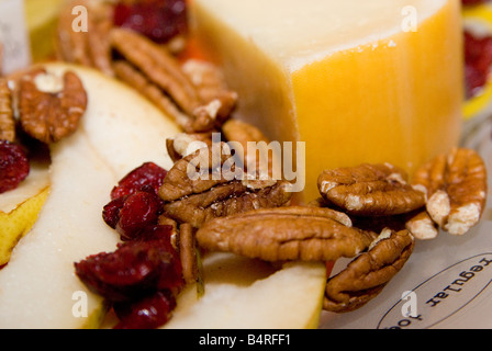 cheese dried fruit nuts and pear on a platter Stock Photo