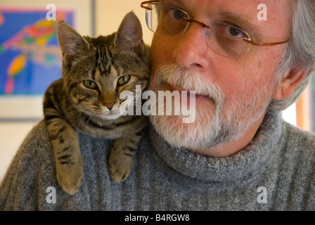 Bearded middle aged man wearing glasses with cat on his shoulder Stock Photo