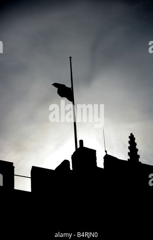 City of Lancaster, England. Silhouetted view of a flag at half mast on HM Prison Lancaster Castle Crown Court battlements. Stock Photo