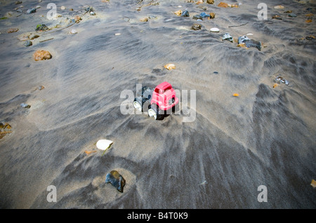 Toy dump truck washed up on beach Stock Photo