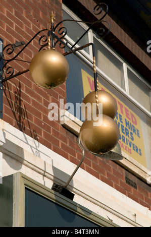 Three balls traditional pawn brokers symbol outside pawn shop Preston Lancashire England UK Stock Photo
