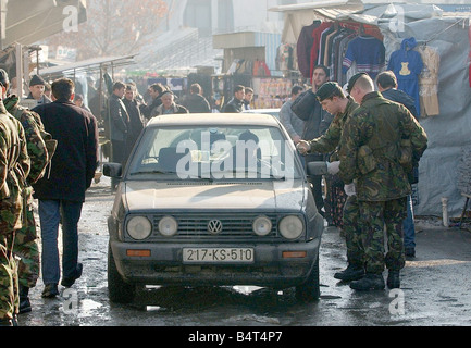 Queens Royal Hussars duty in Kosovo as apart of the KFOR peace keeping mission Soldiers check the ID of a driver at the market place Stock Photo