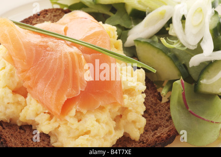 Freshly Prepared Cured Smoked Salmon Fish and Scrambled Egg on Brown Toast Isolated Against A White Background with No People And A Clipping Path Stock Photo