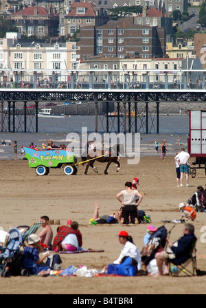 Typical British holiday a horse drawn carriage gives rides to holidaymakers overlooked by the pier and town of Weston Super Mare 2000 s WESTON BRUMMIES MAIL PIC WORDS ALISON D Stock Photo