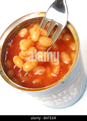A fork removing baked beans from an open tin. Stock Photo