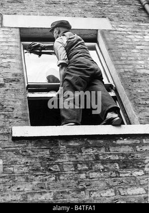 A worried householder understood that sitting on the sill to clean the windows was breaking the law but while the law says nothing about sitting on window sills it does expressly forbid standing on them for the purpose of cleaning or painting unless the windows are those of the basement Stock Photo