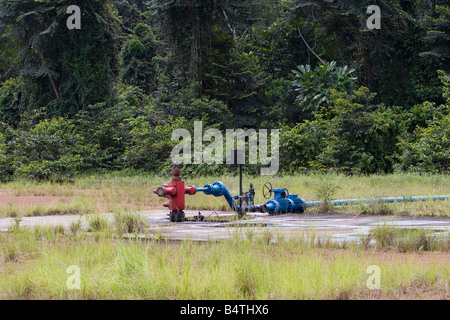 Automatic oil well head in remote forest clearing on onshore oil production site in rainforest, Gabon, Western Africa Stock Photo