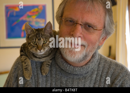 Bearded middle aged man wearing glasses with cat on his shoulder Stock Photo