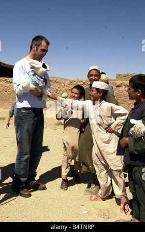 Actor Neil Morrissey pictured in Afghanistan with the No Strings charity teaching mine awareness using puppets June 2003 Pictured with children from the Shaidayee Refugee Camp Stock Photo