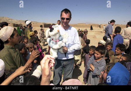 Actor Neil Morrissey pictured in Afghanistan with the No Strings charity teaching mine awareness using puppets June 2003 Pictured with children from the Shaidayee Refugee Camp Stock Photo