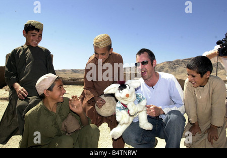 Actor Neil Morrissey pictured in Afghanistan with the No Strings charity teaching mine awareness using puppets June 2003 Pictured with children from the Shaidayee Refugee Camp Stock Photo