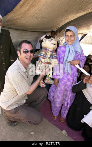 Actor Neil Morrissey pictured in Afghanistan with the No Strings charity teaching mine awareness to children using puppets June Stock Photo