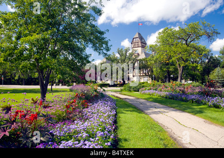 The pavilion at the Assiniboine Park with a pathway lined with decorative flowers in Winnipeg Manitoba Canada Stock Photo