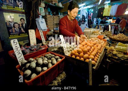 A local street vendor selling a variety of eggs and other local delicacies at the Wan Chai wet market in Hong Kong. Stock Photo