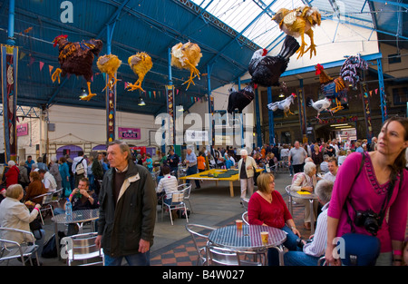 Crowds of people wander sit and browse stalls in Market Hall at Abergavenny Food Festival Stock Photo