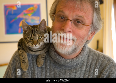 Bearded middle aged man wearing glasses with cat on his shoulder Stock Photo