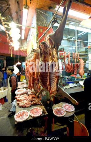 Whole sides of beef hanging for sale at the Wan Chai wet market in Hong Kong. Stock Photo