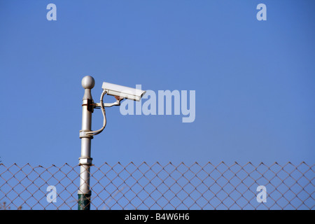 one cctv camera on high pole outdoors in sun Stock Photo