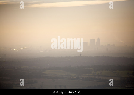 Aerial view south west over Epping Forest Essex looking towards the O2 Stadium and Canary Wharf skyline in smog CM16 SE10 E14 En Stock Photo