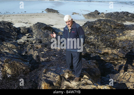 Ships Accidents Disasters Pollution Oil Spillage November 2002 Oil Tanker Prestige Northern Spain Spanish Fisherman Guillermo Vazquze with sea weed from the beach the beach has been affected by the sinking Stock Photo