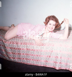 Heller Toren model actress 1964 lying on bed pink striped shirt Stock Photo