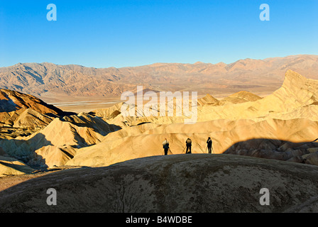 Three photographers catching the perfect shot of sunrise at Zabriskie Point in Death Valley National Park in California. Stock Photo