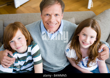 Father in the middle of son and daughter Stock Photo