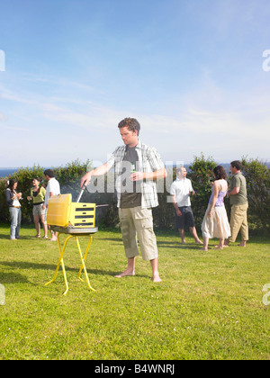 Man tending barbecue at a party Stock Photo