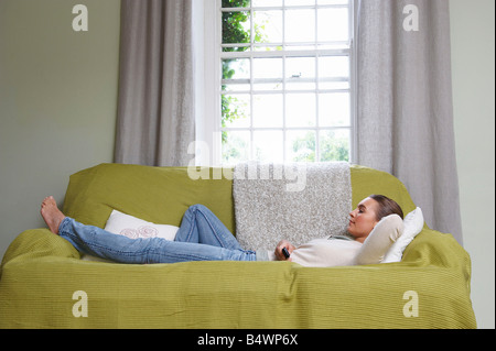 Young woman lying on couch Stock Photo