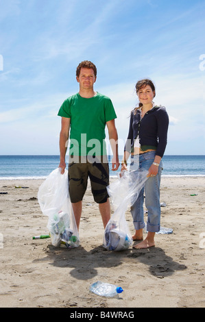 Young couple collecting garbage on beach Stock Photo