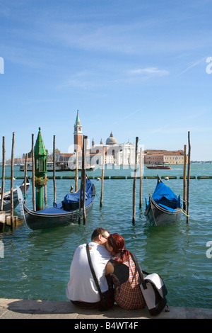 Couple together in Venice looking out to the Basilica San Giorgio Maggiore across the Lagoon Stock Photo