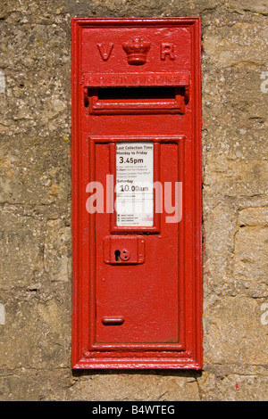 Old GPO red post box in Cotswold wall UK Stock Photo