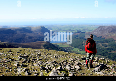 A walker enjoys the view of Ennerdale Water from the summit of Scoat Fell Stock Photo