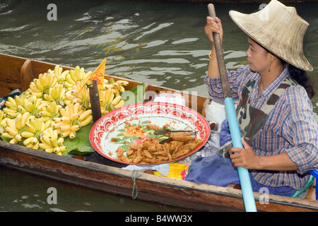 Damnoen saduak Floating Market, a bygone way of life in Ratchaburi. A  popular floating market with vendors in wooden boats on waterways in Thailand. Stock Photo