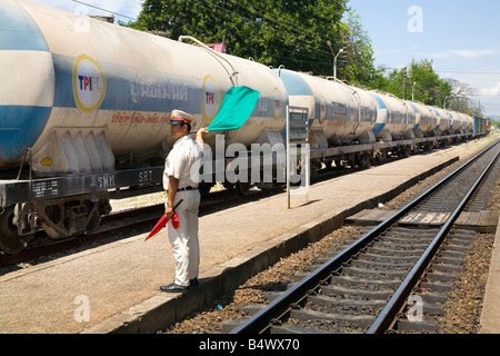 Asian Signalman waving green flag Signal for freight train, signals and signalling at Hua Hin, Railway Station, Thailand Stock Photo