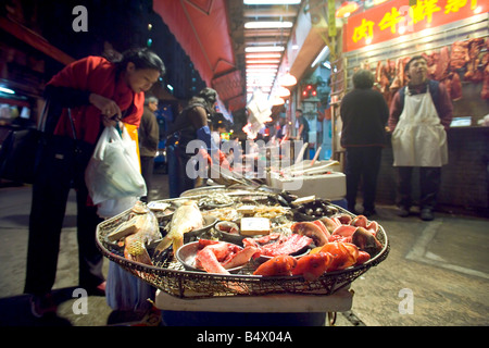 Hong Kong Wan Chai wet market Jan 2005 Local woman buying fish at the wet market Stock Photo