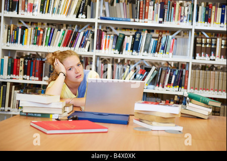 Bored young woman in library Stock Photo