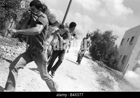 some palestinians running away from tear gas shot by israeli soldiers during a protest against the israelis building the separat Stock Photo