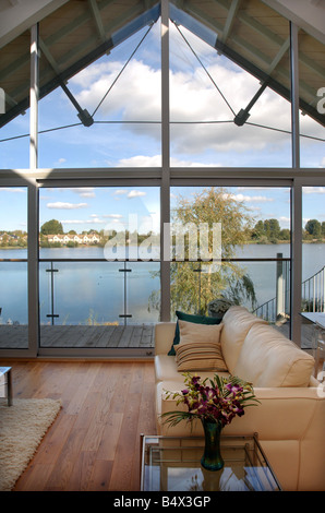 A CONTEMPORARY LIVING ROOM WITH A BALCONY IN A WATERSIDE APPARTMENT AT THE LOWER MILL ESTATE NEAR CIRENCESTER GLOUCESTERSHIRE UK Stock Photo