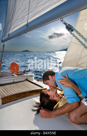 Couple laying on sailboat, kissing Stock Photo