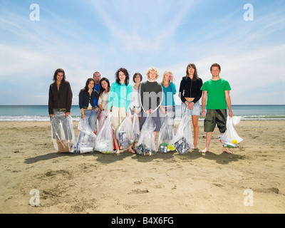 Young people collecting garbage on beach Stock Photo