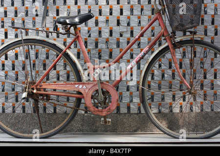Old women's bicycle leaning against a tiled wall. Stock Photo