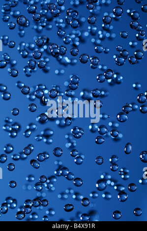 Water Droplets Captured in Mid Air Against a Blue Background Stock Photo
